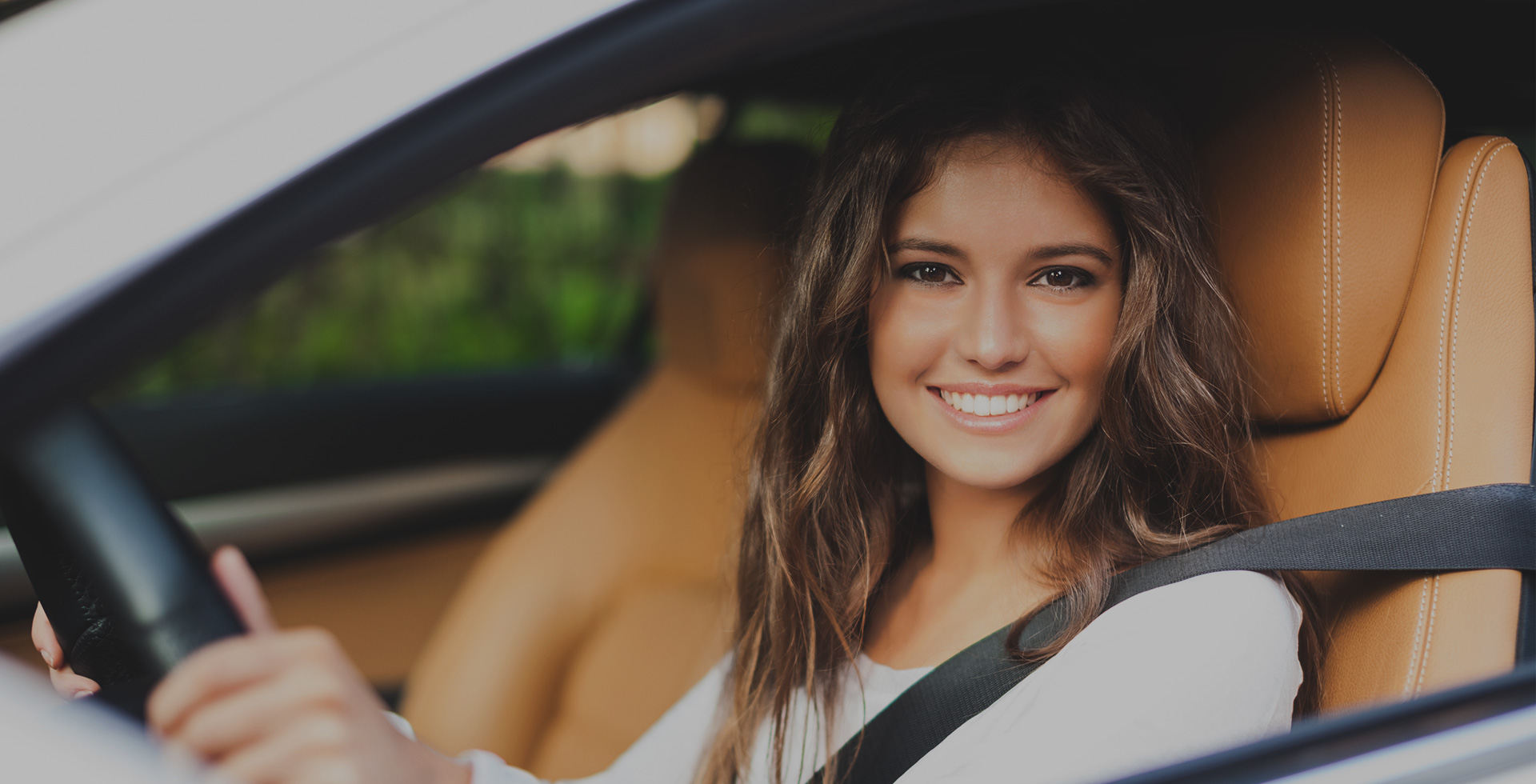 Woman driving car smiling